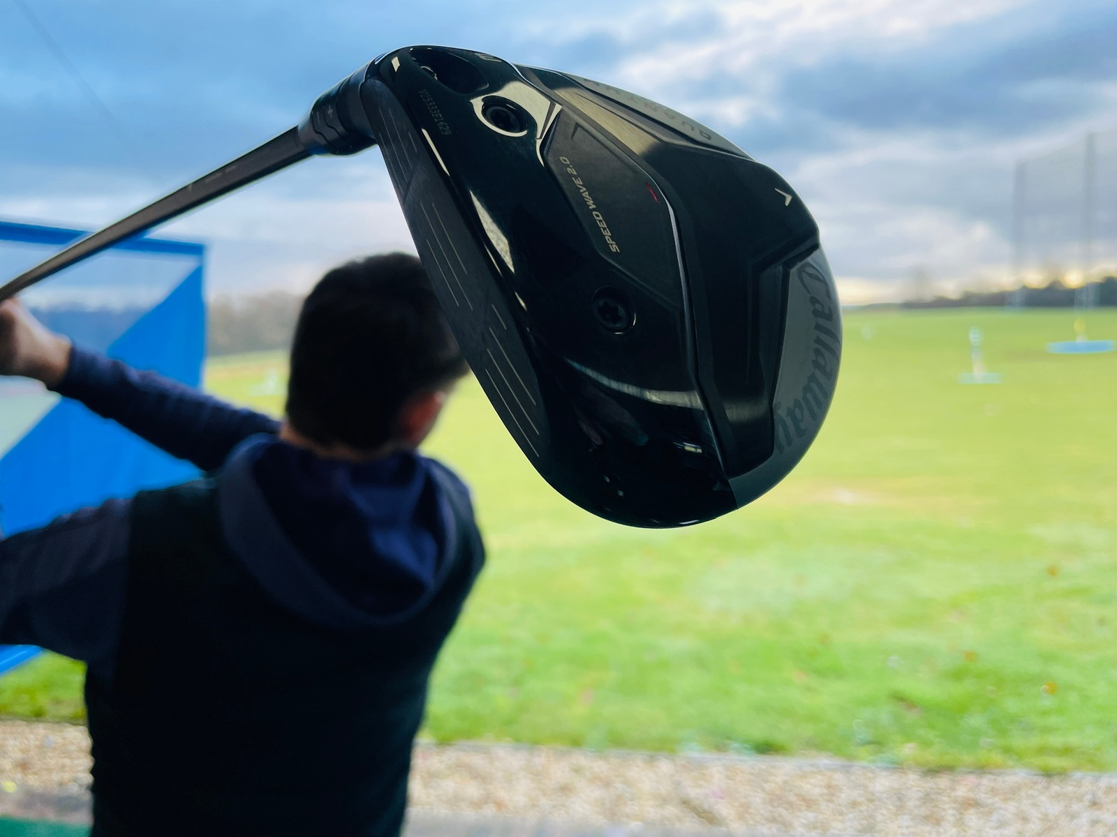 Golfer with a driver looking out across the range at Winchester Golf Academy